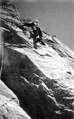 Alpinist med plezanjem po strmi steni, varovan z vrvjo.