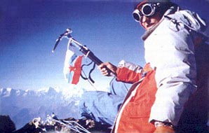 Alpinistka z jugoslovansko zastavo na vrhu gore v snežni opremi.